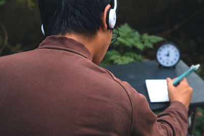Rear view of man using mobile phone