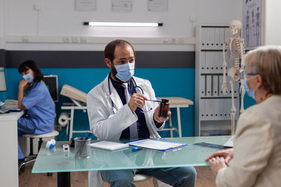 Female dentist examining patient in laboratory