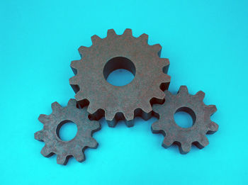 Close-up of metallic gears against blue background