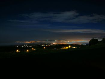 Illuminated city against sky at night