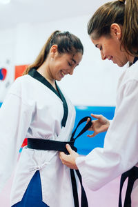 Young women wearing belt during taekwondo practice