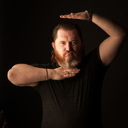 Portrait of young man against black background