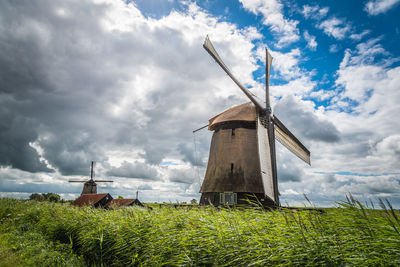 Traditional windmill on field against sky