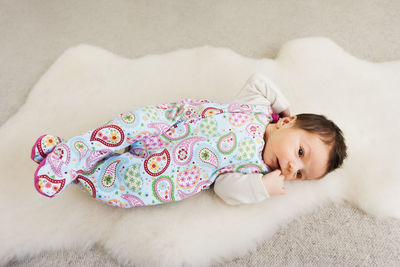 High angle view of cute baby girl lying on bed