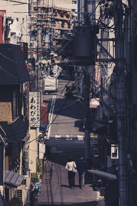 People walking on street amidst buildings in city