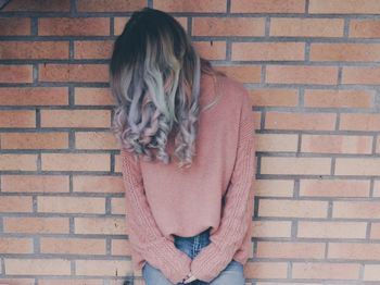 Woman standing on brick wall