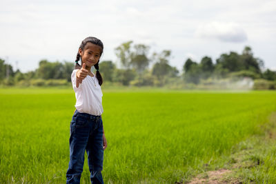 Outdoor portrait of a little girl farmer on rice fields