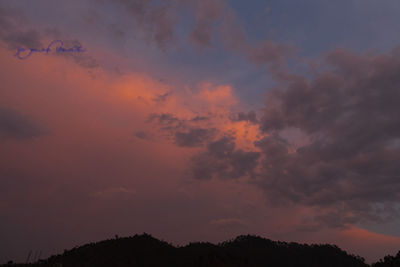 Low angle view of silhouette trees against dramatic sky