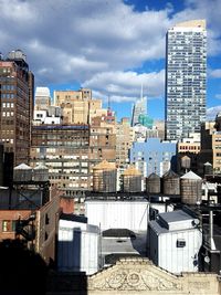 Buildings in city against cloudy sky