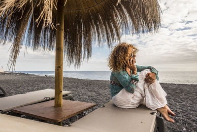 Woman talking on mobile phone at beach