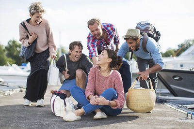 Group of friends enjoying on pier at harbor