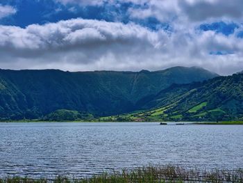 Scenic view of lake by mountains against sky