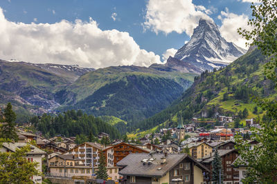 Panoramic view of townscape and mountains against sky