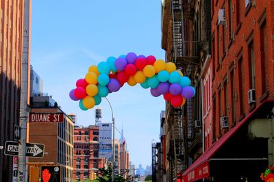 Low angle view of colorful balloons against blue sky