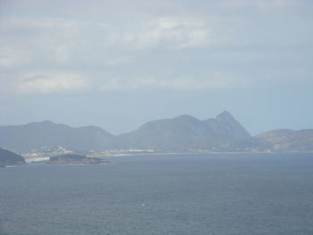 Scenic view of sea and mountains against sky