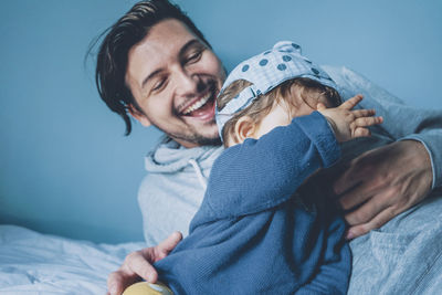 Cheerful father playing with daughter at home