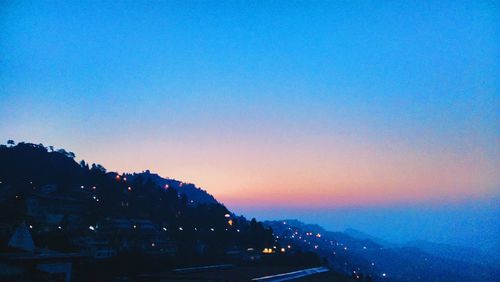 View of illuminated cityscape at sunset
