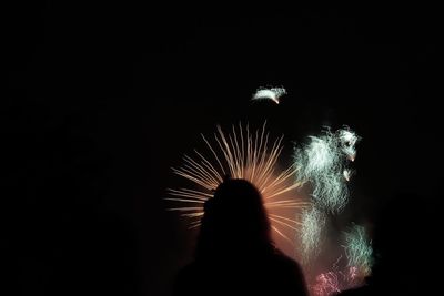 Low angle view of fireworks against sky at night