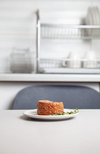 Plate of pet food on kitchen table, selective focus