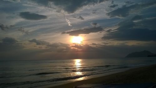 Scenic view of sea against dramatic sky during sunset