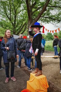 People standing by tree trunk