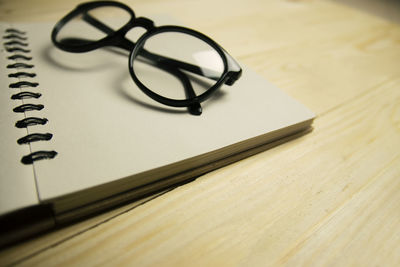 Close-up of eyeglasses on spiral notebook at table