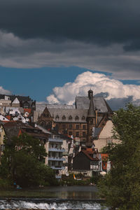 Houses by river against sky