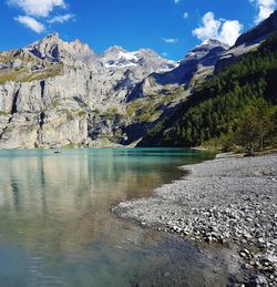 Scenic view of lake by mountains against sky