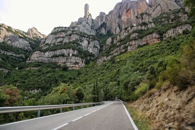 Road amidst rocky mountains against sky