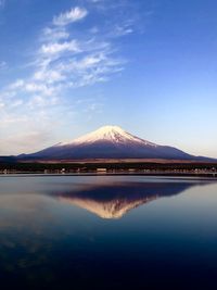 Scenic view of lake and mountains against blue sky