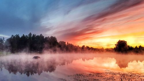 Scenic view of lake against sky at sunset