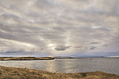 The sun approaching the horizon behind the clouds over breiðafjörður in iceland