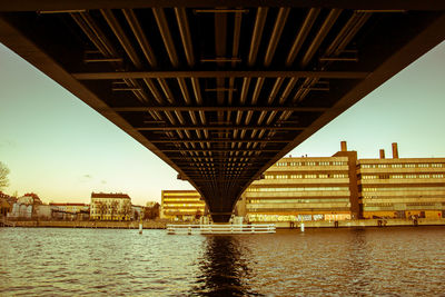 Bridge over river in city against sky