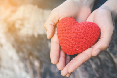 Cropped image of woman holding knitted heart