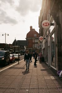 People walking on street amidst buildings in city