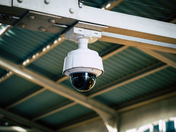 Low angle view of security camera hanging from ceiling in train station, berlin