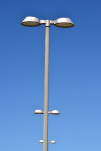 Low angle view of street light against clear blue sky