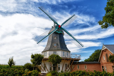 Low angle view of traditional windmill against sky