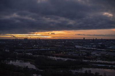 Aerial view of city buildings against sky at sunset