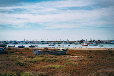 Boats moored at harbor against sky