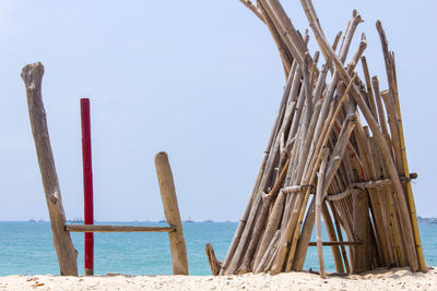 Wooden posts on beach against clear sky