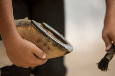 A close-up photo of a horse's hoof in his hand during cleaning