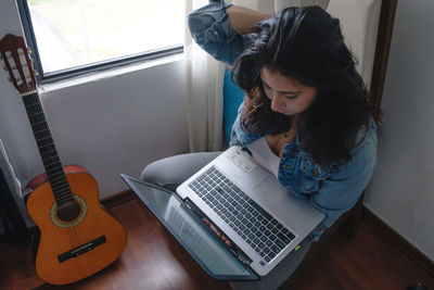 High angle view of young woman using laptop while sitting at home