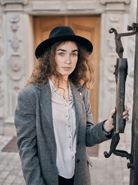 Portrait of young woman wearing hat standing outdoors