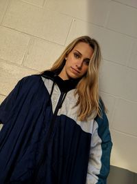 Portrait of beautiful young woman against wall