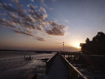 Pier over sea against sky during sunset