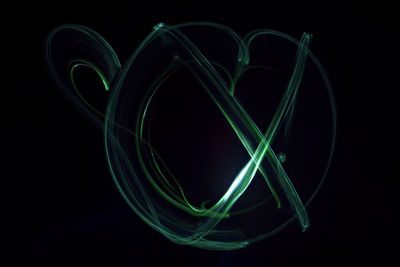 Close-up of green light trails against black background