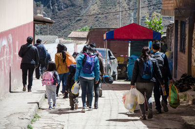 Rear view of people walking on footpath