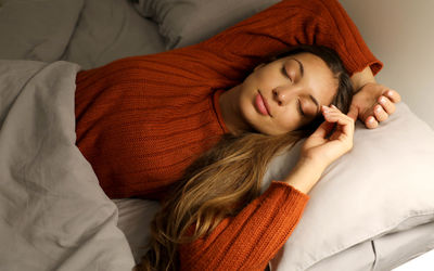 Young woman sleeping on bed at home