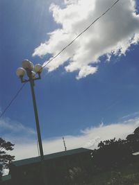 Low angle view of power lines against cloudy sky